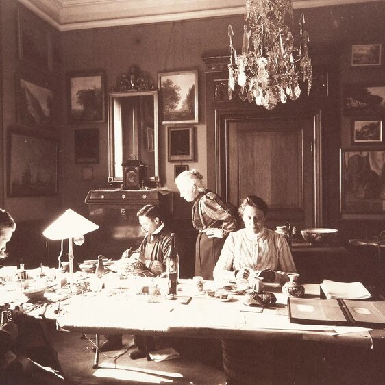 Wilhelmina (stehend) überwacht 1907 die Inventarisierung von Sammlungs- und Fundobjekten.